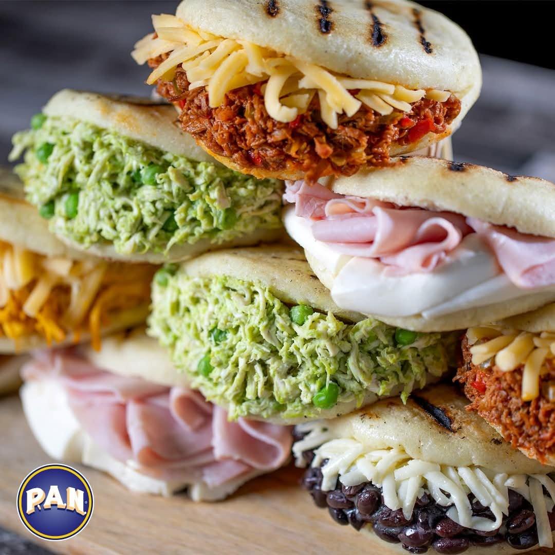Stack of arepas with reina pepiada, ham, shredded beef and black bean fillings