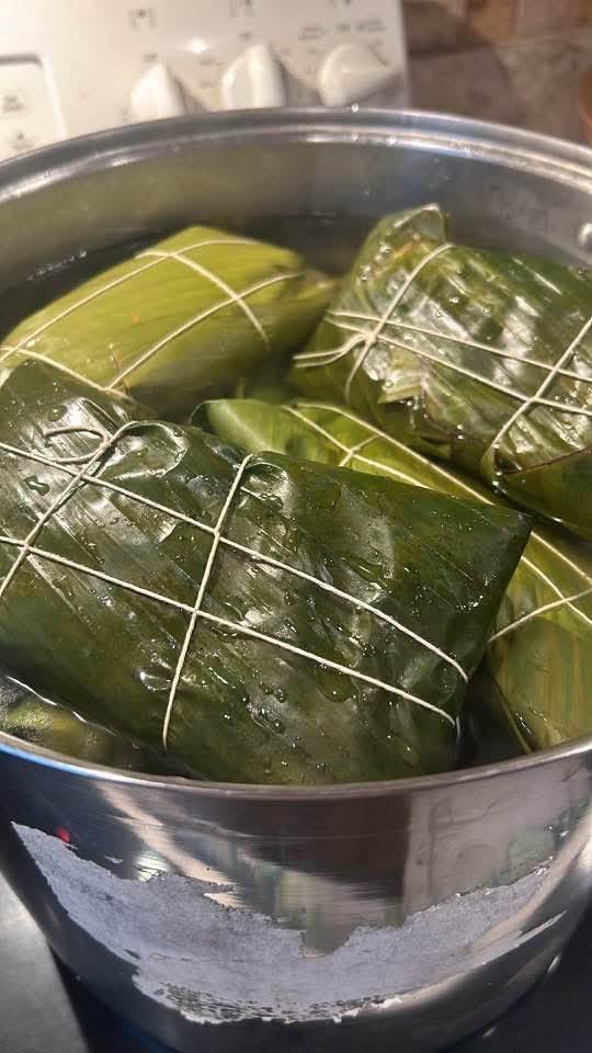 Hallacas tied with string boiling in a pot